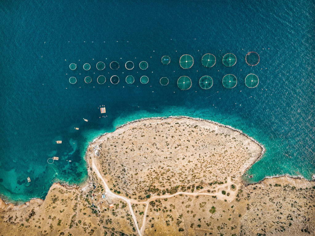 Overhead drone shot of fish farms off the coast in greece